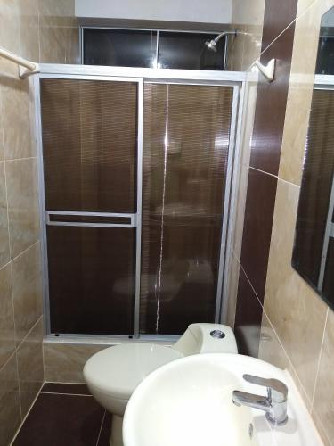 a bathroom with a shower and a toilet and a sink at D' Barrig in Trujillo