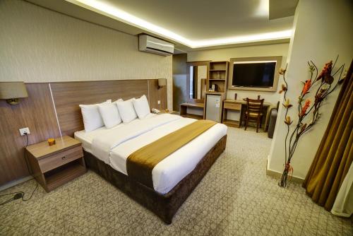 a hotel room with a large bed and a table at Nairoukh Hotel Aqaba in Aqaba