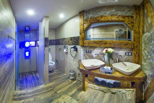 a bathroom with a sink and a toilet and a mirror at Hotel Kocourkov in Hlinsko