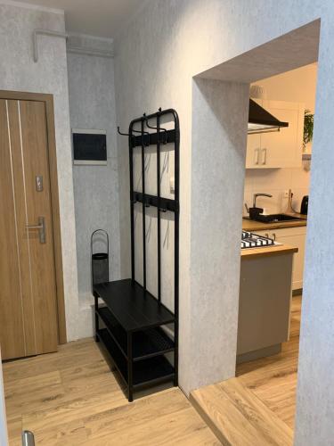 a kitchen with a black shelf in the middle of a room at Apartamenty Dobranocka in Krotoszyn