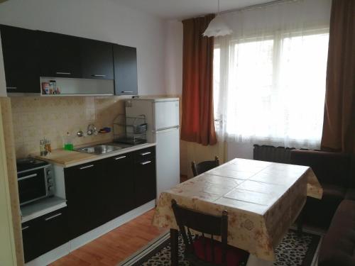 una cocina con mesa y una pequeña cocina con mesa y mesa en Guest Rooms Metaksinovi, en Chepelare