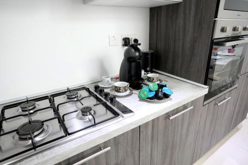 a kitchen with a stove top and a counter top at Escape to St Julians in St Julian's