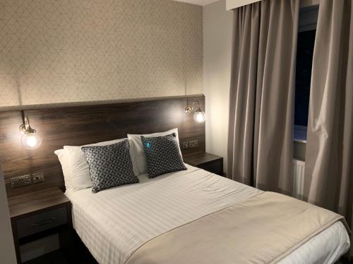 a bedroom with a large bed with two pillows at Trafford Hall Hotel Manchester, Trademark Collection by Wyndham in Manchester