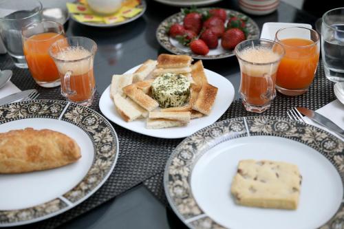 a table with plates of food and glasses of orange juice at Escape to St Julians in St Julian's