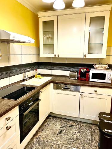 a kitchen with white cabinets and a sink at Apartment Ani in Ramsau am Dachstein