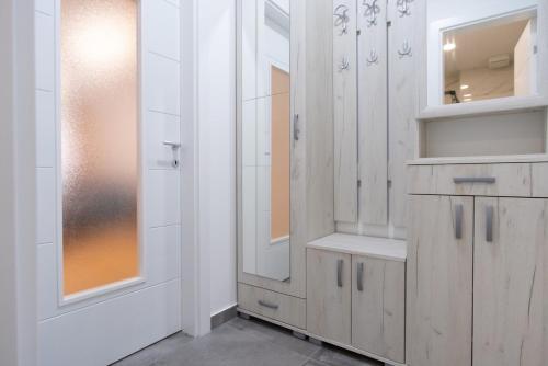 ein Badezimmer mit weißen Schränken und einem Spiegel in der Unterkunft Trebinje Star in Trebinje