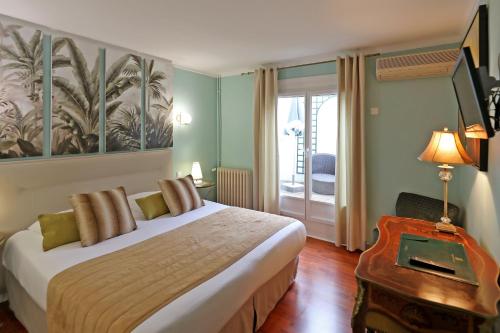 En eller flere senge i et værelse på Hotel Les Pasteliers