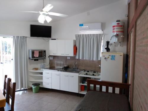 eine Küche mit weißen Schränken und einem weißen Kühlschrank in der Unterkunft El Tatu in La Bolsa