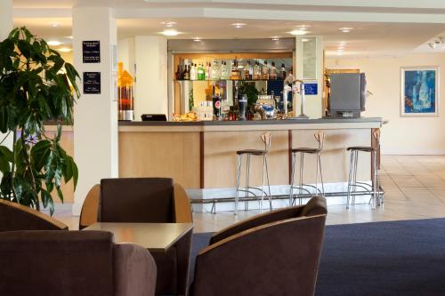 a kitchen with a table and chairs in it at Holiday Inn Express Cardiff Airport, an IHG Hotel in Rhoose