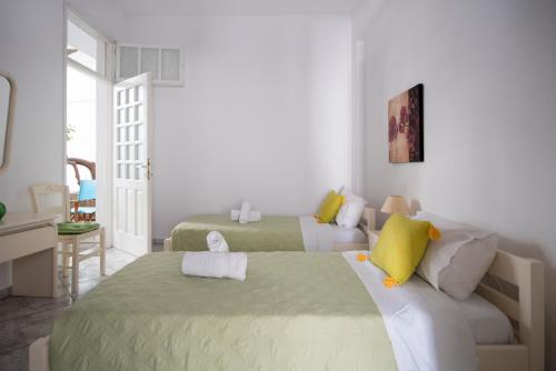 a bedroom with two beds and a living room at White Rooms Paros in Naousa
