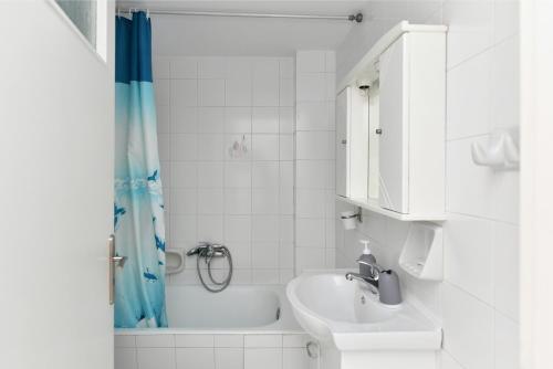 a bathroom with a sink and a tub and a toilet at White Rooms Paros in Naousa