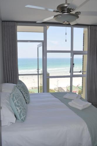 a bedroom with a bed with a view of the beach at 808 St Tropez in Cape Town