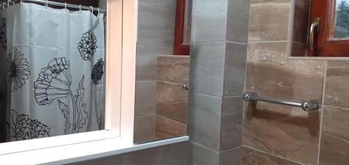 - un rideau de douche dans la salle de bains pourvue d'une fenêtre dans l'établissement Apartments Gaga, à Jahorina