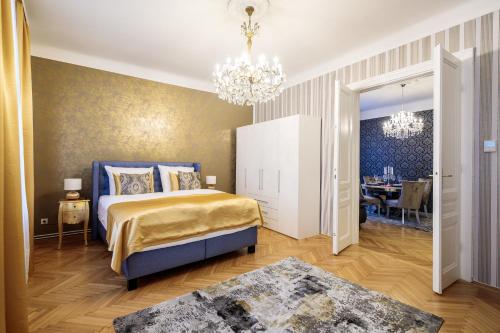 a bedroom with a bed and a chandelier at Sophies Place Augarten - Imperial Lifestyle City Apartments Vienna Parking in Vienna