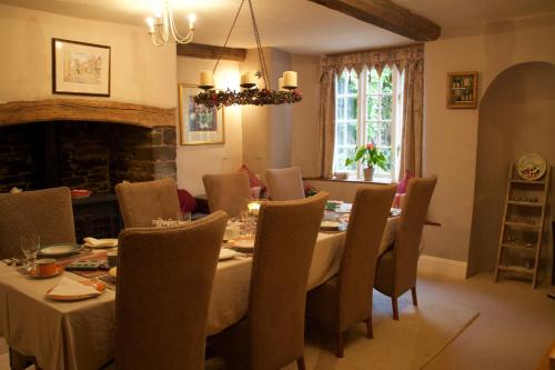a dining room with a table and chairs and a fireplace at Court Barton Farm in Aveton Gifford