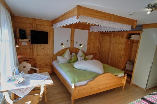 a bedroom with a bed and a table in a room at Biobauernhof Gehrnerhof am Arlberg in Warth am Arlberg