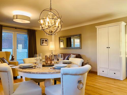 a dining room and living room with a table and chairs at Ferien-Apartment Sandmuschel - mit priv Strandzugang in Friedrichshafen