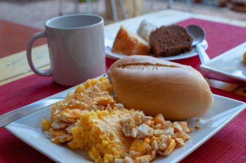 a plate of food with a sandwich and a cup of coffee at Hostel Barra in Salvador