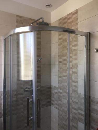 W łazience znajduje się prysznic ze szklanymi drzwiami. w obiekcie Villa Caramel w mieście Saint-Quentin-la-Poterie
