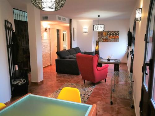 - un salon avec un canapé noir et des fauteuils jaunes dans l'établissement Casa Montalbán Apartamentos Turísticos, à Grenade
