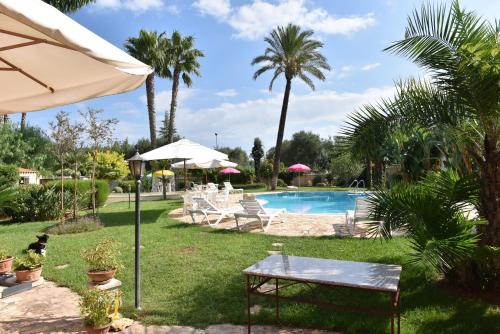 een zwembad met een tafel en een parasol bij B&B Villa Anastasia Club in Mesagne