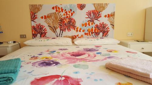 a large bed with a flower pattern on it at LA PERLA DEL CENTRO LAGO DI COMO in Perledo