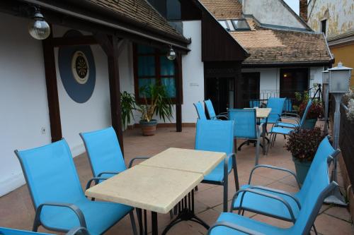 a group of blue chairs and tables on a patio at Főtér Apartmanház Szentendre in Szentendre