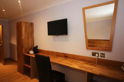 a room with a flat screen tv on the wall at Westone Manor Hotel in Northampton