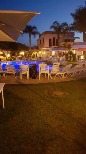a group of chairs and a swimming pool at night at B&B Villa Anastasia Club in Mesagne