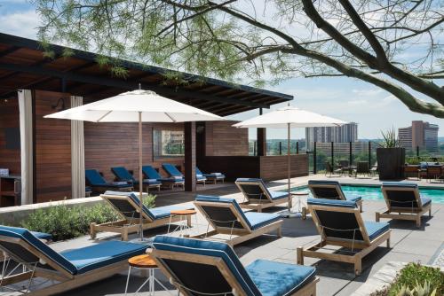 a group of chairs and umbrellas next to a pool at Hotel Van Zandt in Austin