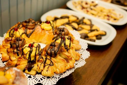 a table topped with plates of pastries on plates withller at Ribera Sur Hotel Mar del Plata in Mar del Plata