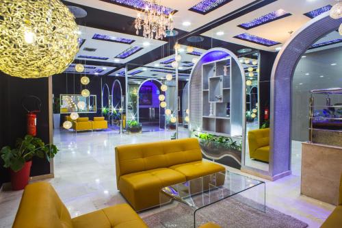 a lobby with yellow furniture and a chandelier at Hôtel Tanjah Flandria in Tangier