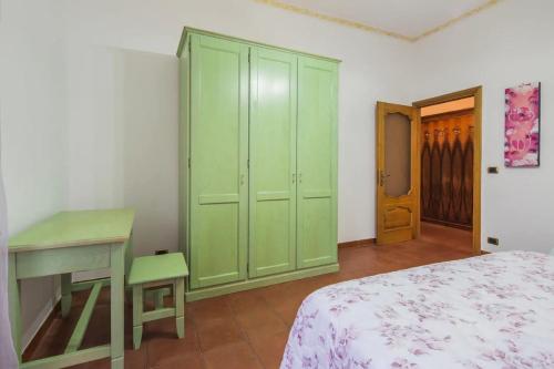 una camera da letto con armadi verdi, un letto e una scrivania di La Calcara di Nonno Raffaele ad Agerola