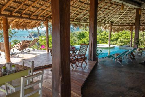 einen Pavillon mit einem Pool, Stühlen und einem Tisch in der Unterkunft Hush Maderas in San Juan del Sur