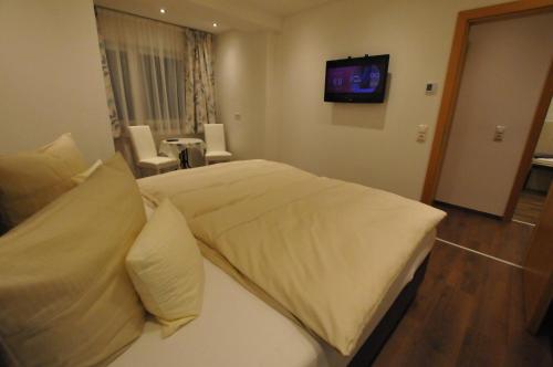 a bedroom with a large bed with a tv on the wall at Haus Passler in Sankt Jakob in Defereggen