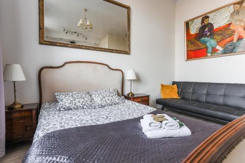 Un dormitorio con una cama, un sofá y un espejo. en SunHouse Apartment, en Toruń