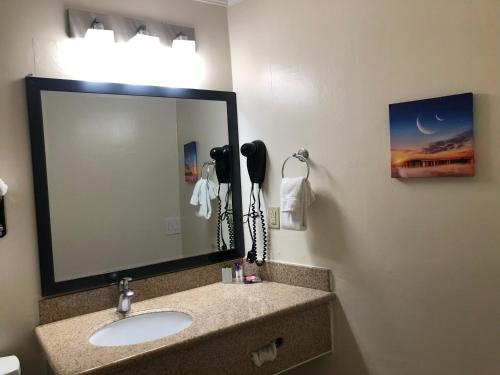 a bathroom with a sink and a mirror at Americas Best Value Presidents Inn on Munras in Monterey