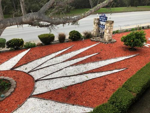 a garden with a flag on the ground at Americas Best Value Presidents Inn on Munras in Monterey