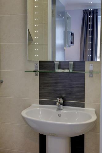 a bathroom with a white sink and a mirror at Sure Hotel by Best Western Reading in Reading