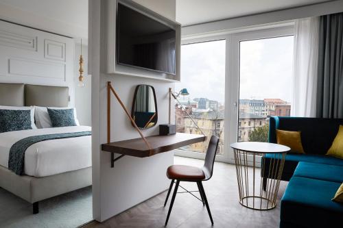 a bedroom with a bed and a table and a chair at Hotel Indigo Dresden - Wettiner Platz by IHG in Dresden