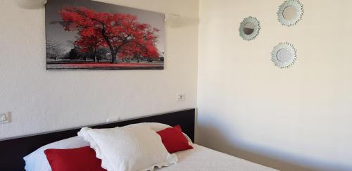 プエルト・デ・ラ・クルスにあるAcogedor estudio Seguro de Solの赤い木の絵が壁に描かれたベッドルーム