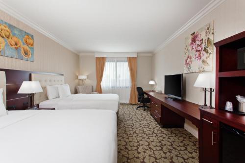 a hotel room with two beds and a television at Holiday Inn El Monte - Los Angeles by IHG in El Monte
