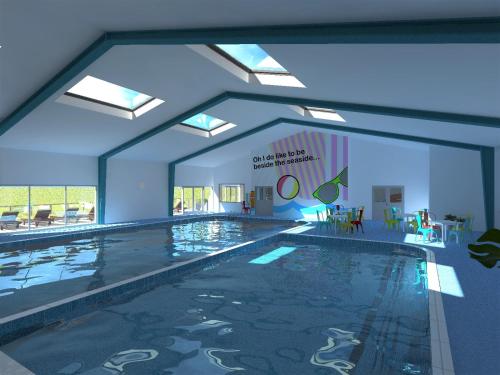 a swimming pool in a building with a large window at Country Coastal Holidays - Families and Couples only in New Romney