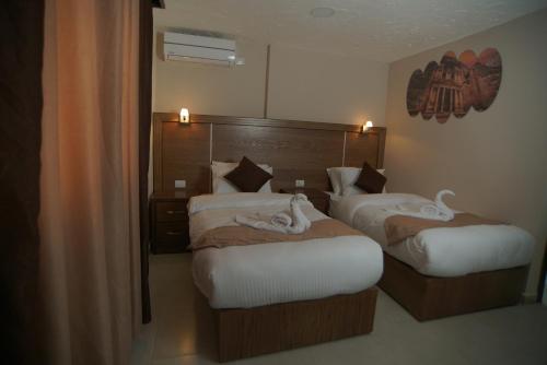 a hotel room with two beds with towels on them at Petra Aretas Hotel in Wadi Musa