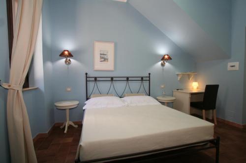1 dormitorio con cama, escritorio y silla en Casa Levante, en Oliveri
