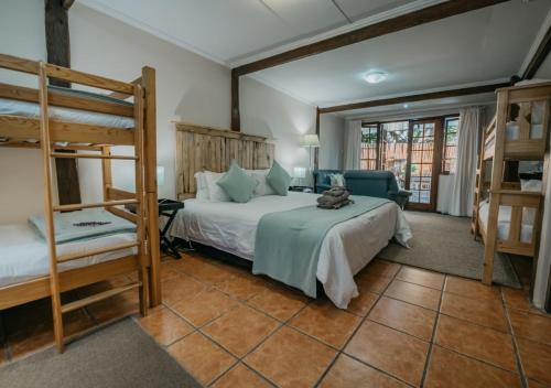 a bedroom with two bunk beds and a couch at The Village Lodge in Stormsrivier