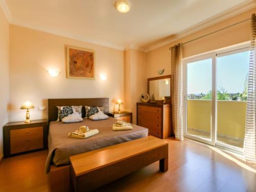 een slaapkamer met een bed en een groot raam bij Luxury Holiday Villa Alegria Galé Beach, Albufeira in Albufeira