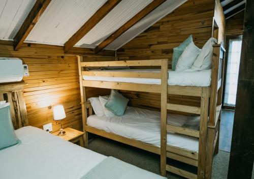 a bedroom with two bunk beds in a cabin at The Village Lodge in Stormsrivier