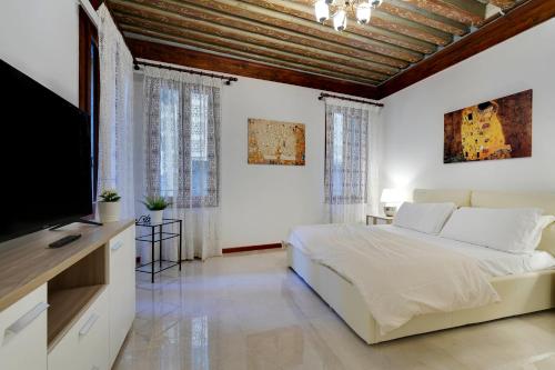 1 dormitorio con 1 cama y TV de pantalla plana en Ca' Rialto, en Venecia
