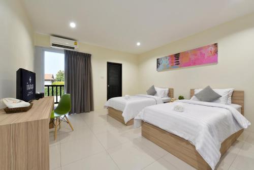 Una habitación de hotel con dos camas y un televisor. en Baan Lamoon, en Ratchaburi